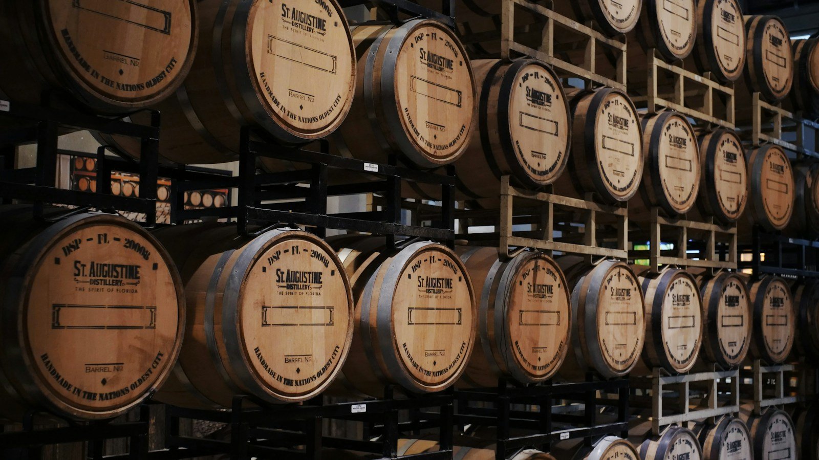 Rows of oak barrels in a whiskey aging warehouse